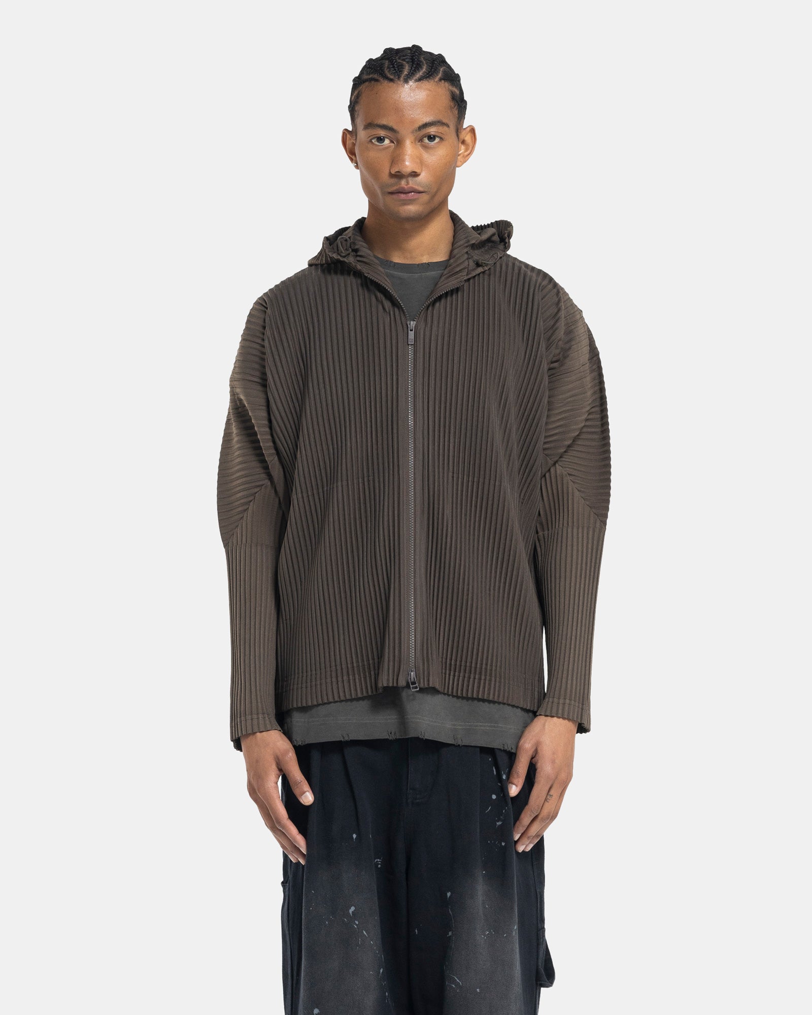 Male model wearing issey miyake homme plissé green pleated hoodie on white background