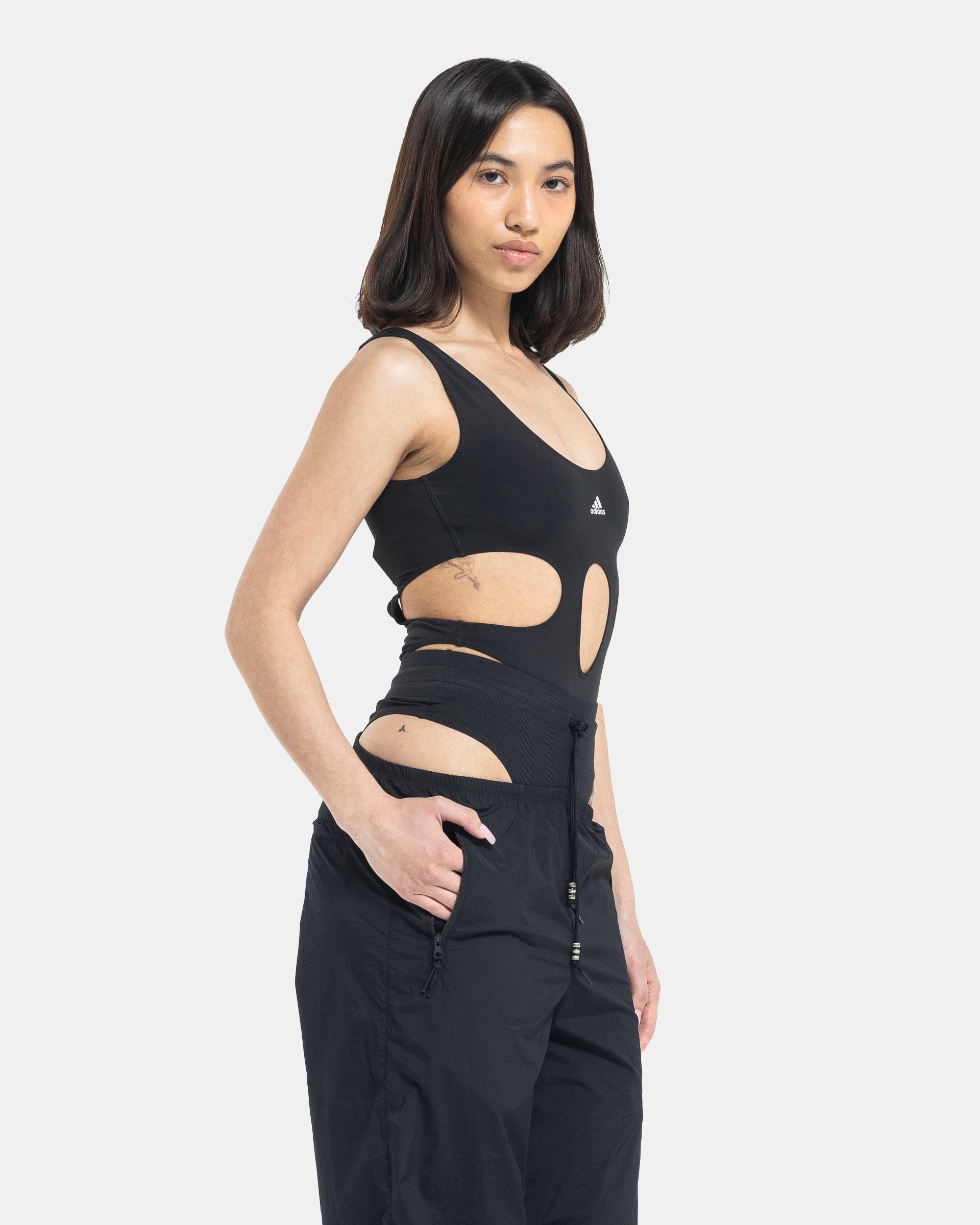 Female model wearing RUI x Adidas Black Bodysuit on white background