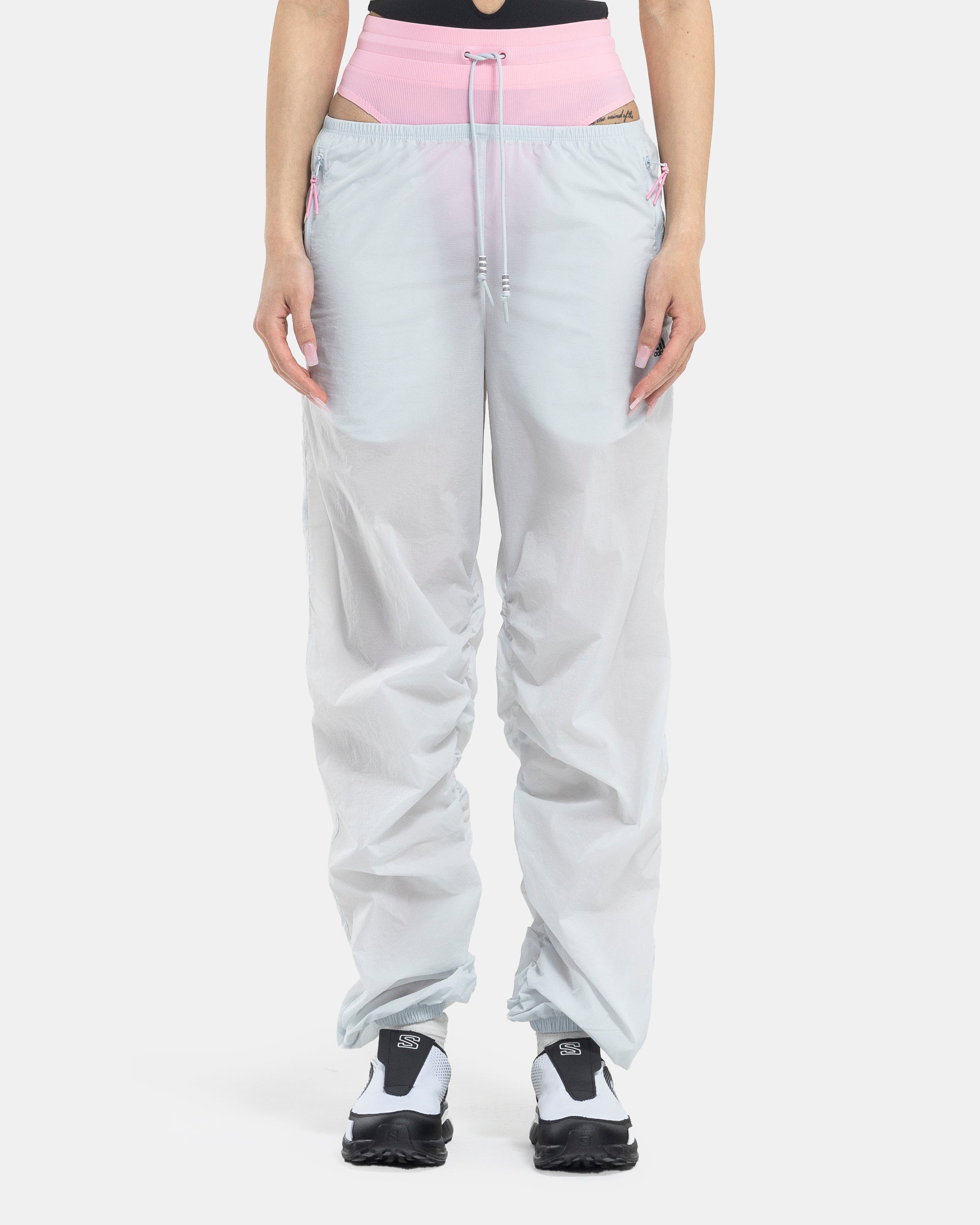 Female model wearing RUI x Adidas Pink Track Pants on white background