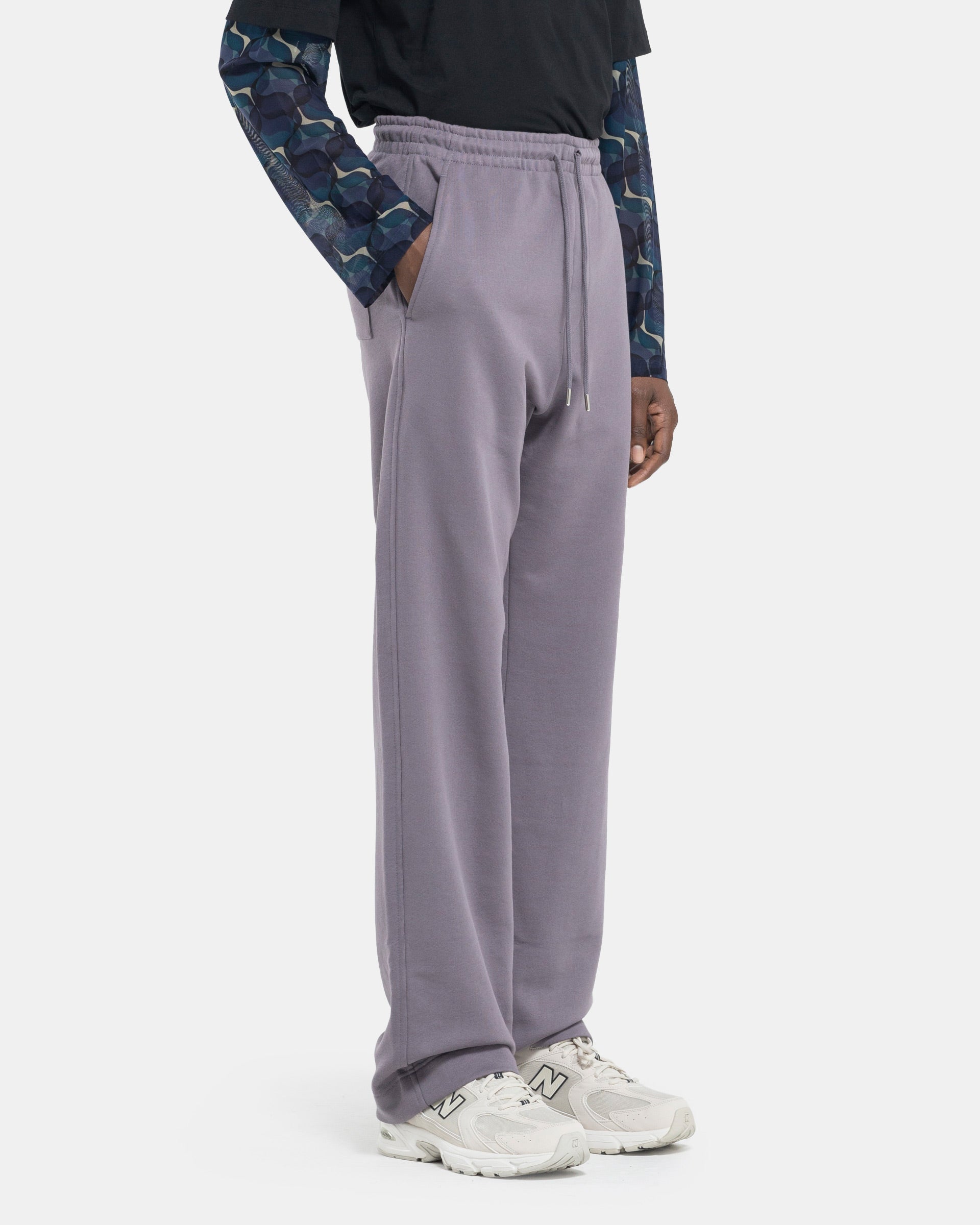 Model wearing Dries Van Noten Hamer Sweatpants in Pruple on a white background