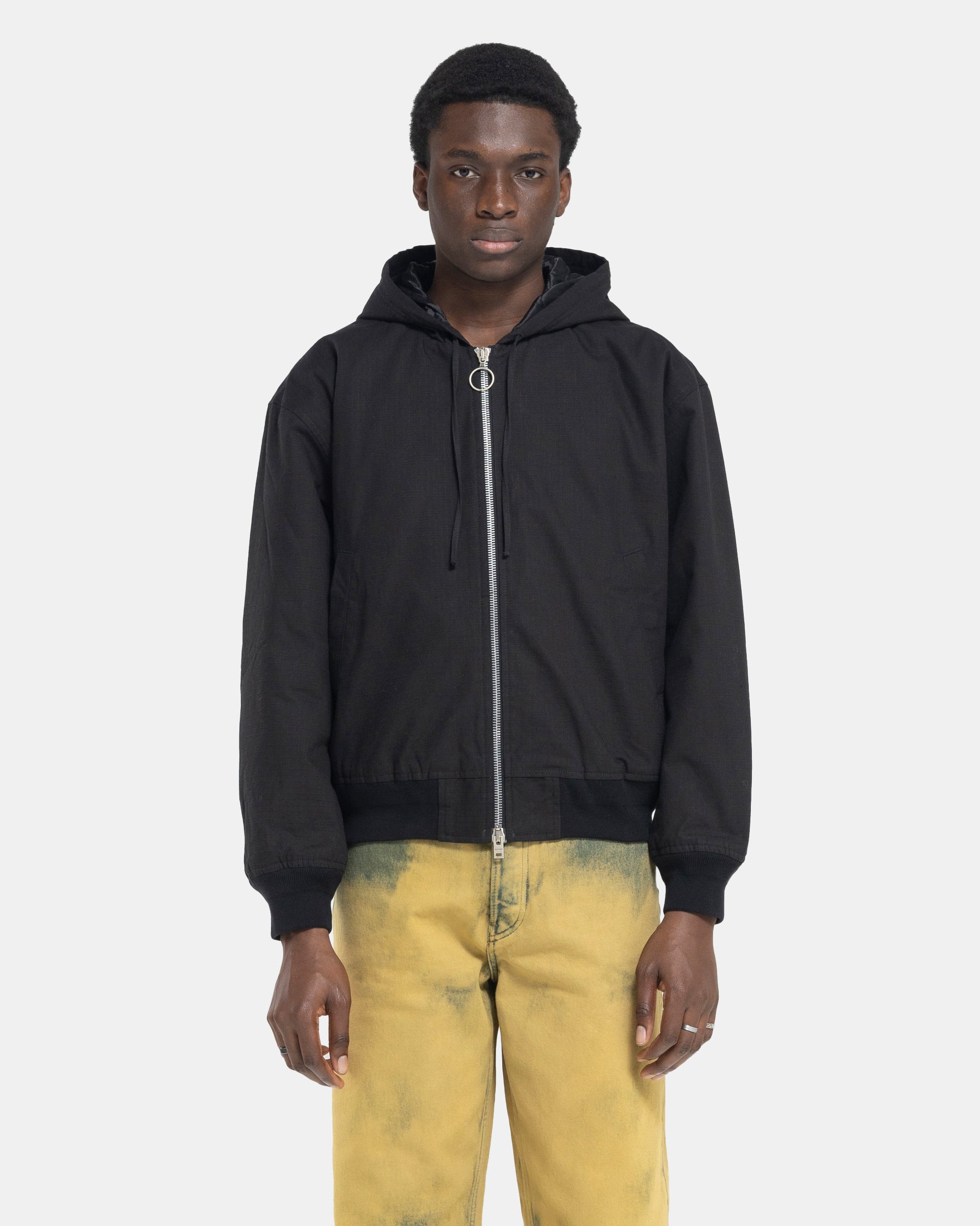 Model wearing Acne Studios Ripstop Padded Jacket in Black on white background