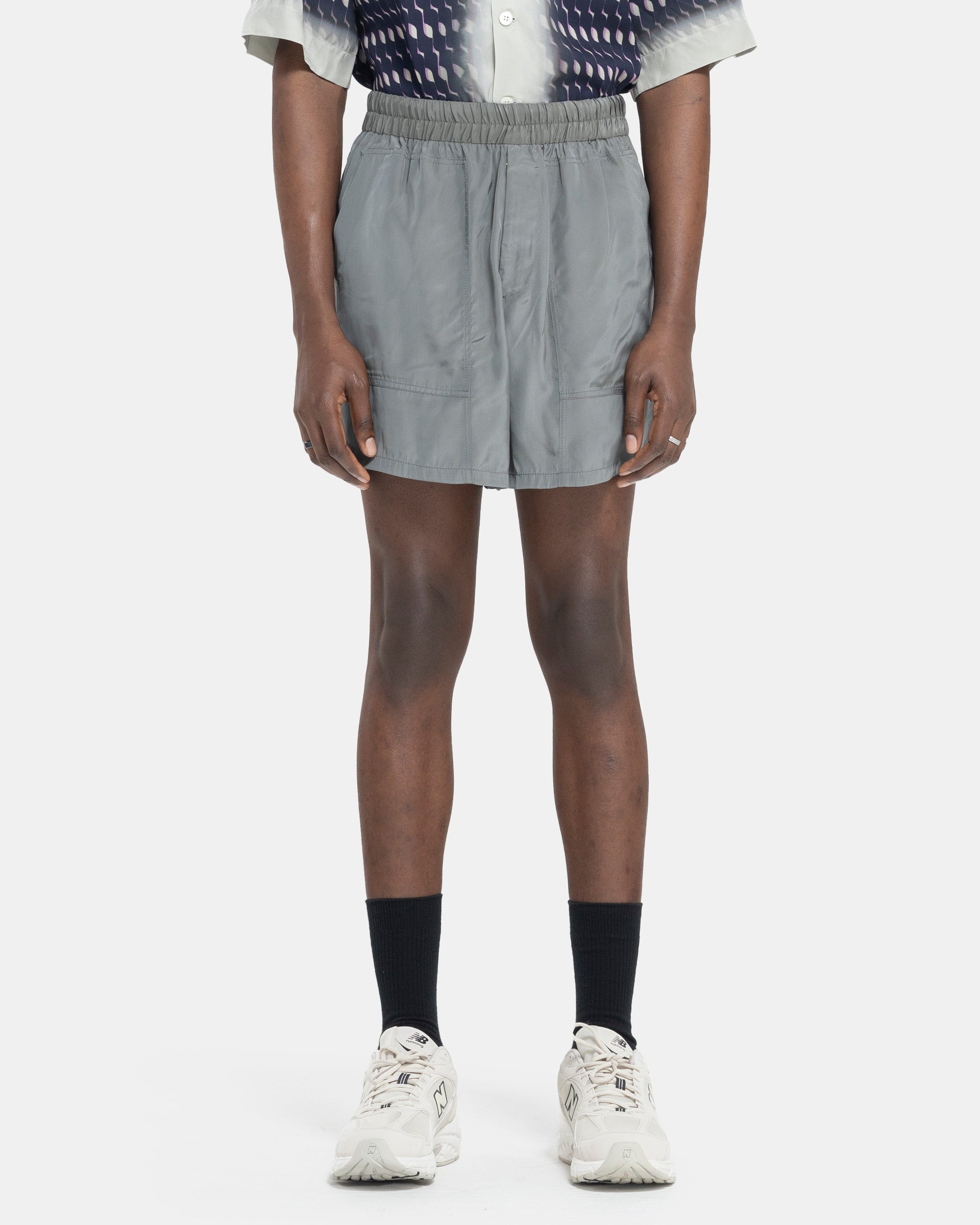 Model wearing Dries Van Noten Pooles Shorts in Grey on white background