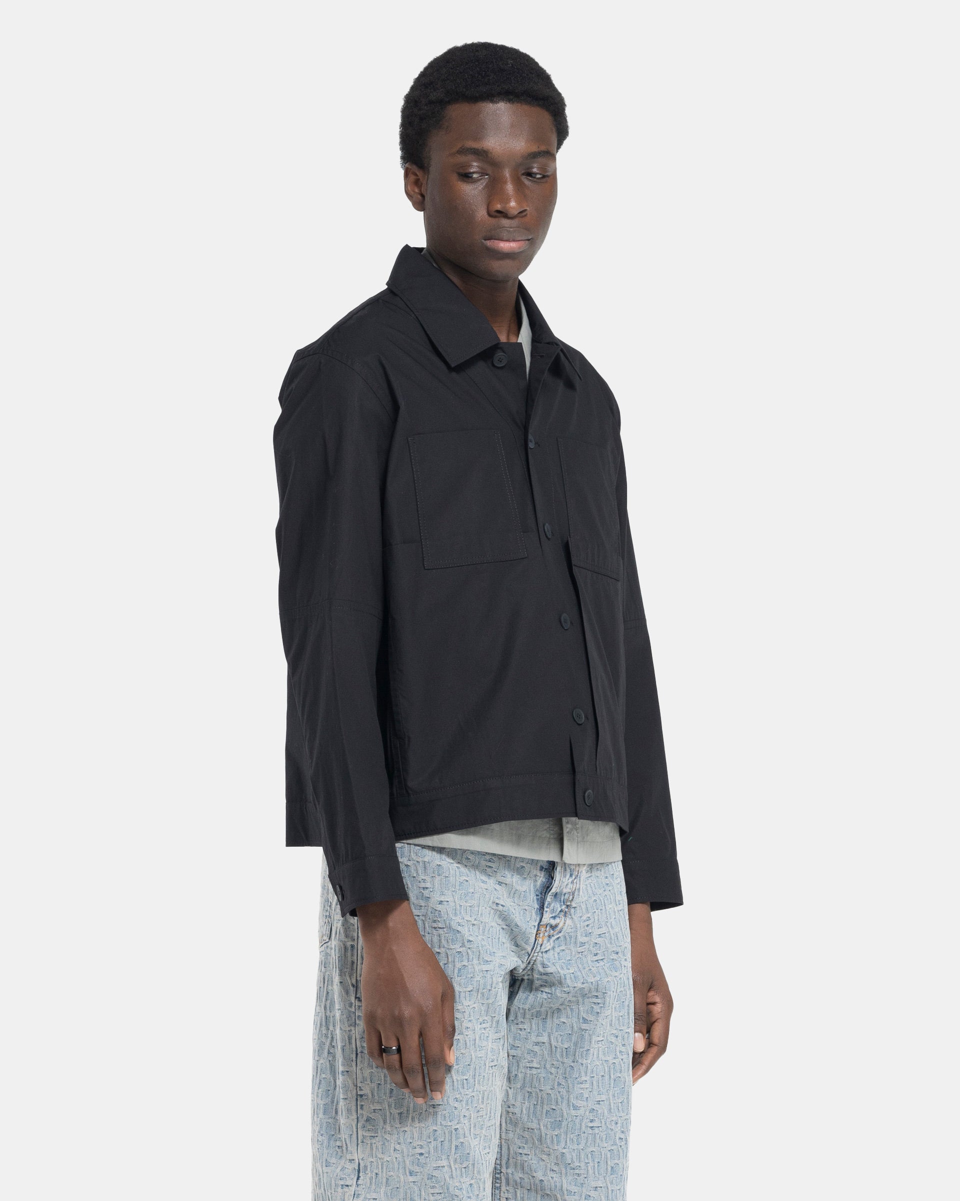 Model wearing Craig Green Worker Jacket in Black on white background