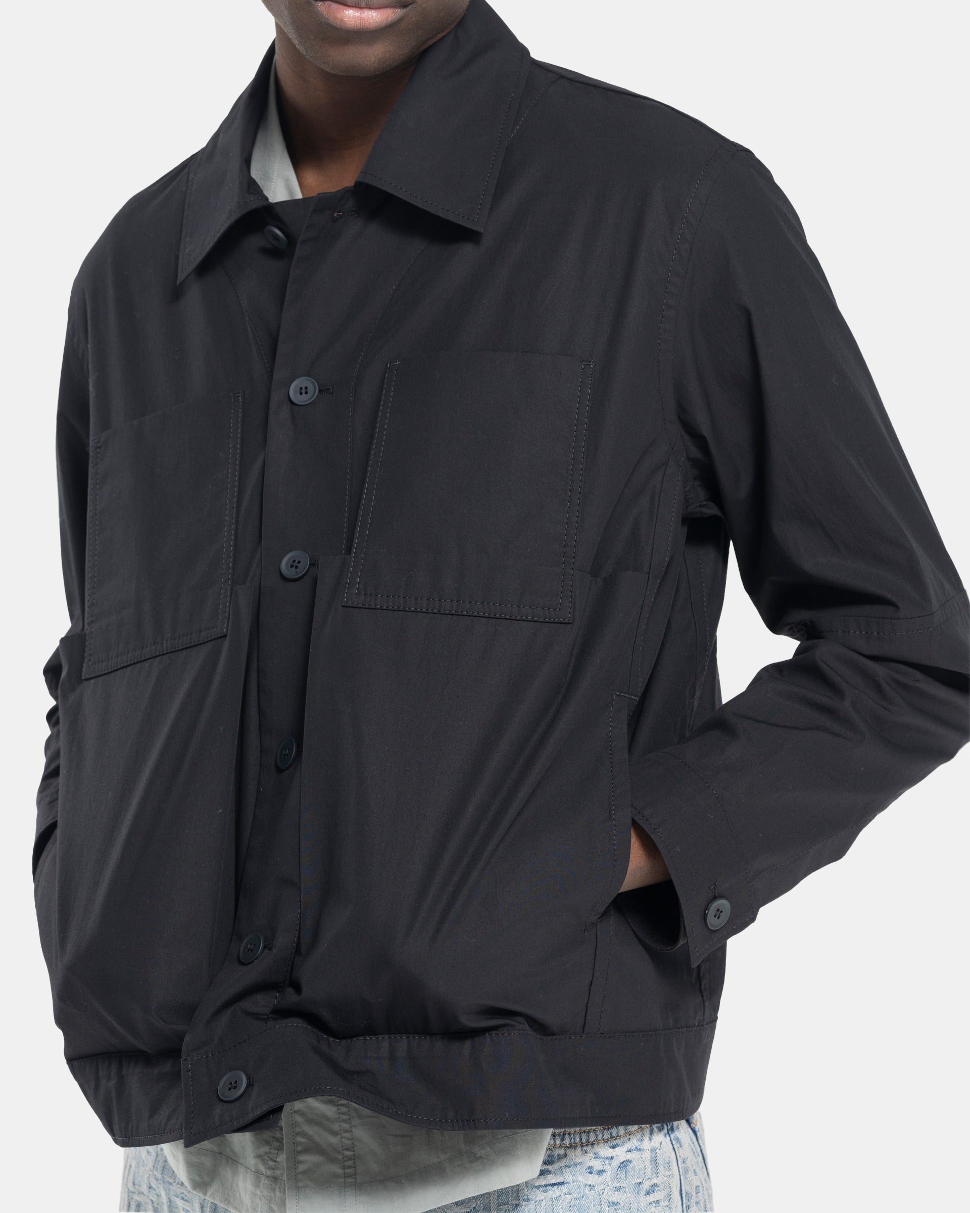 Model wearing Craig Green Worker Jacket in Black on white background