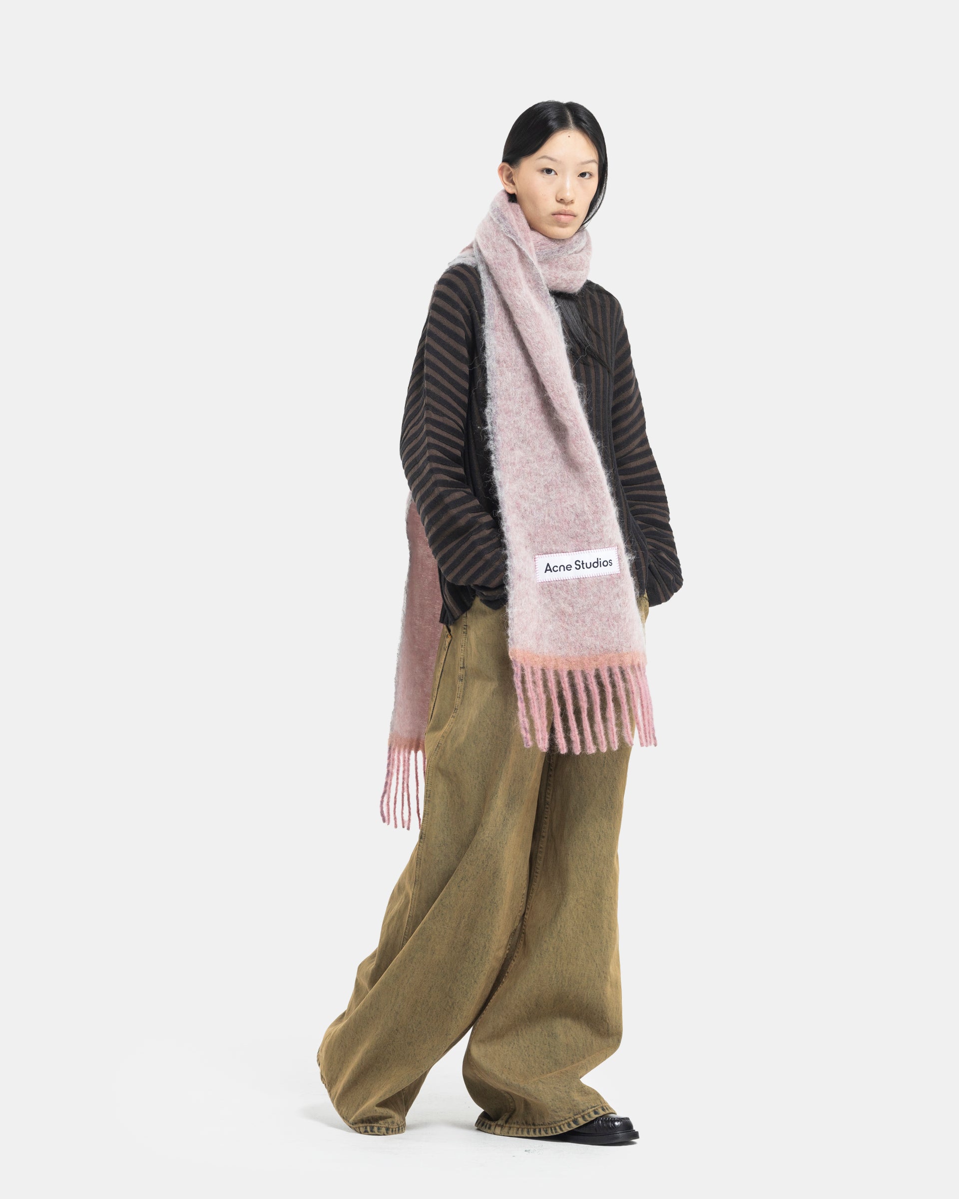 Female model wearing Eckhaus Latta Designer Wool Brown Sweater with knit stripes and Acne Studios Mohair Scarf