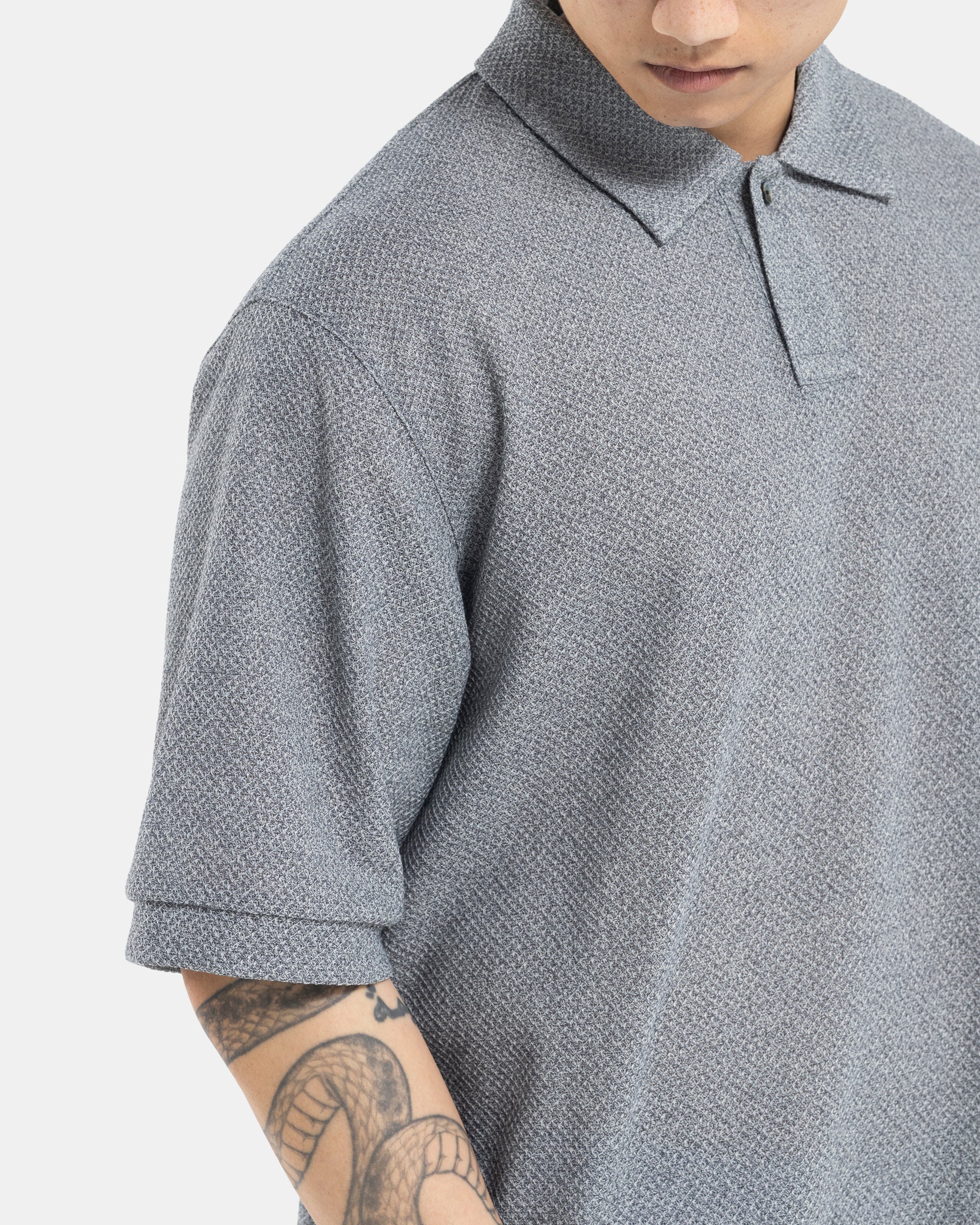 Male model wearing grey Still By Hand polo shirt on white background