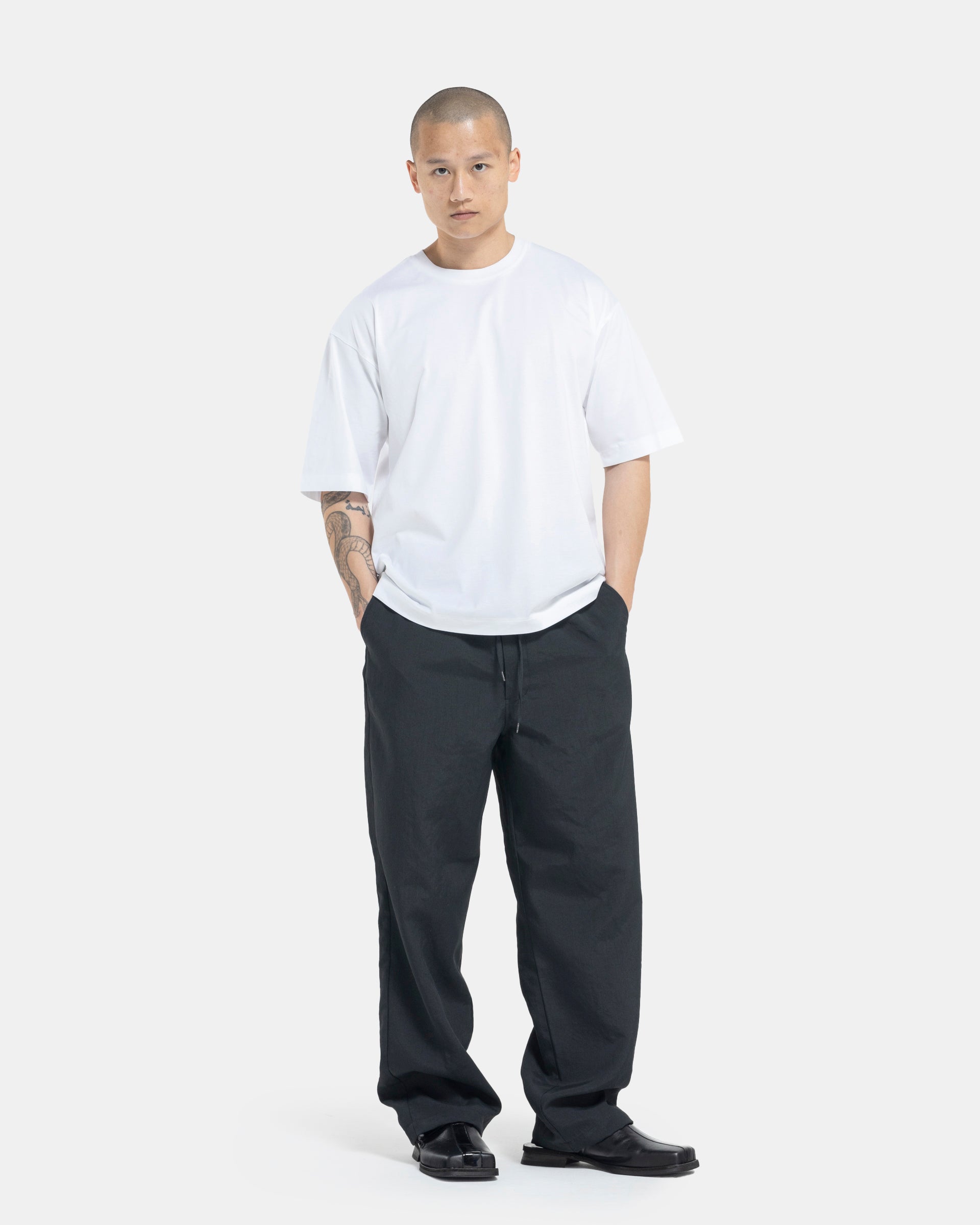 Male model wearing white Still By Hand T-shirt on white background