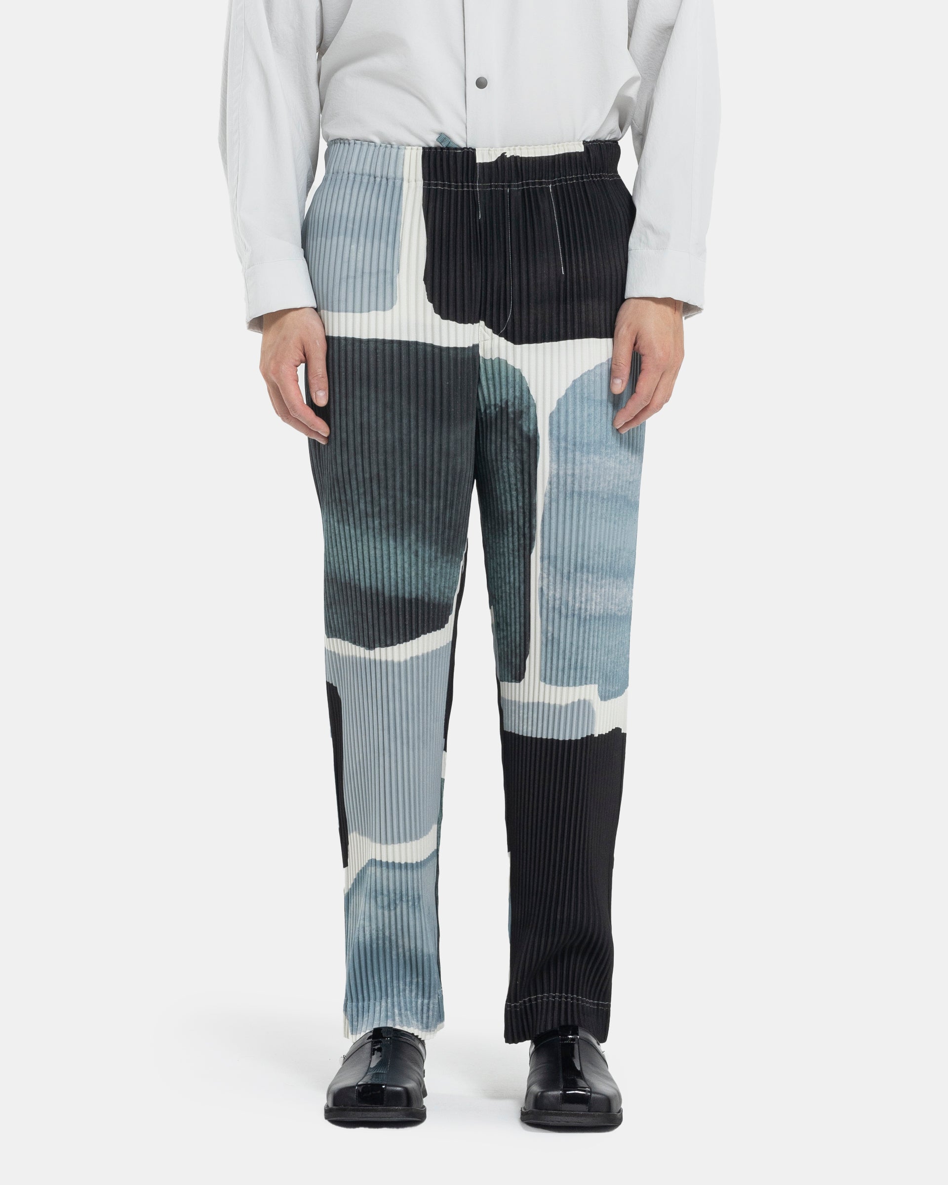 Male model wearing Homme Plissé Issey Miyake printed jacket on white background