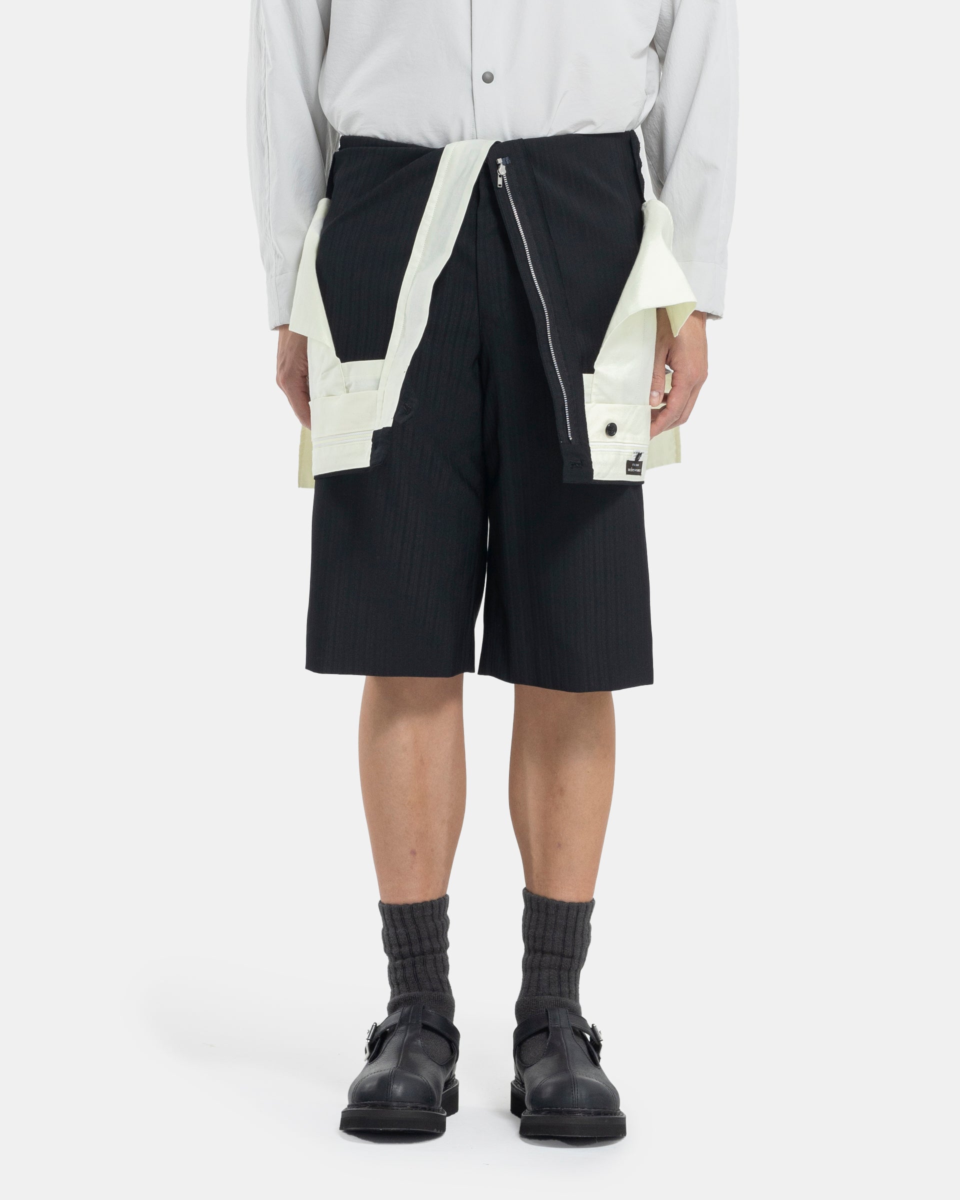 Male model wearing Comme Des Garçons Shorts on white background