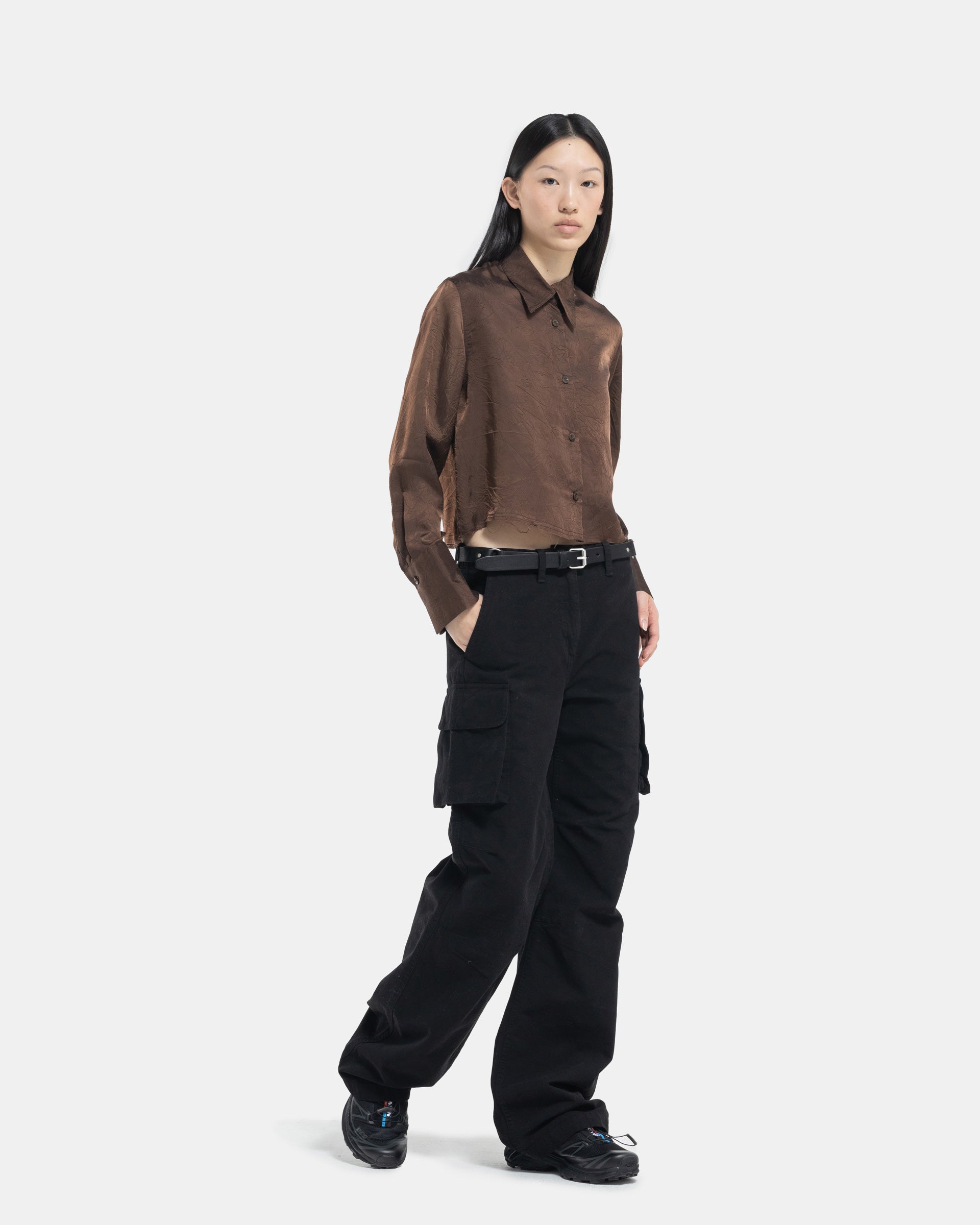 Female model wearing Our Legacy Black Cargo Pants on white background