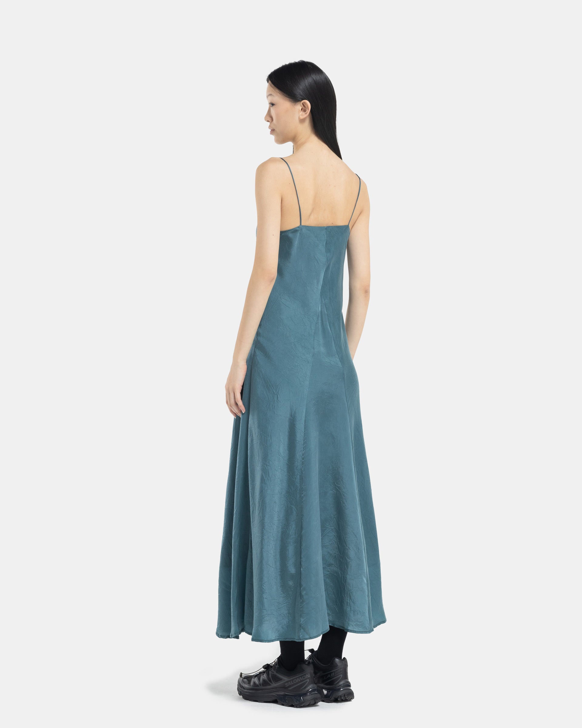 Model wearing blue bias slip dress from Song For The Mute on white background