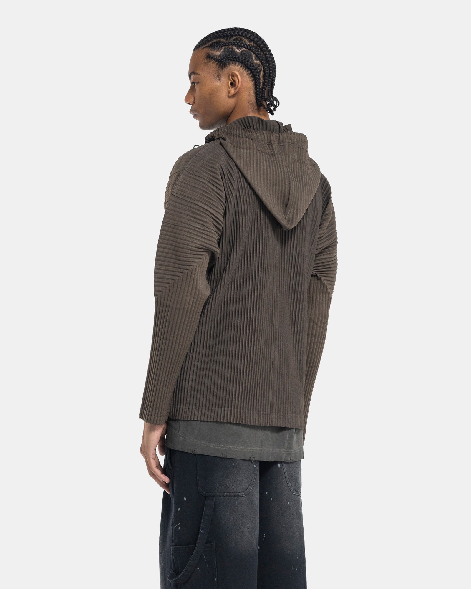 Male model wearing issey miyake homme plissé green pleated hoodie on white background