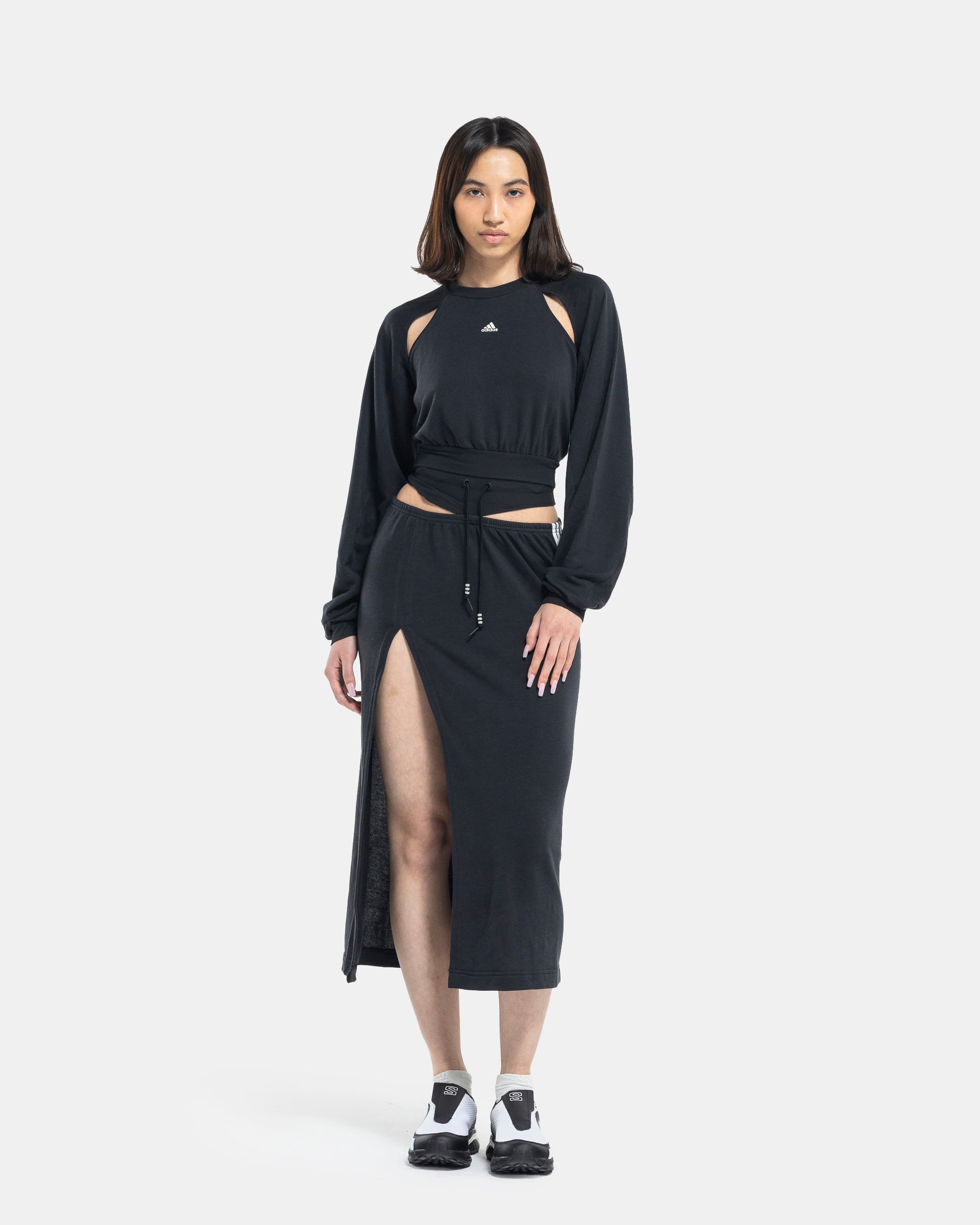 Female model wearing RUI x Adidas Black Skirt on white background