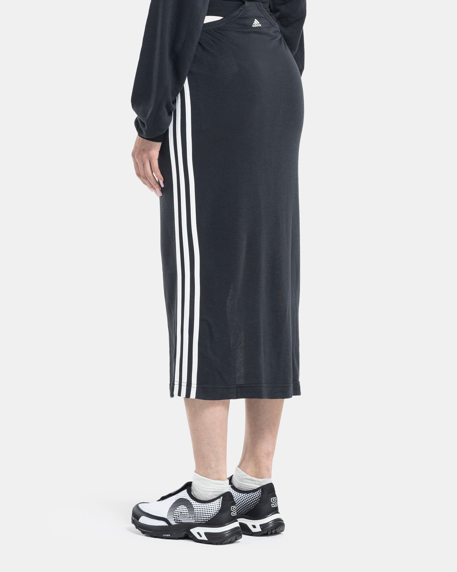Female model wearing RUI x Adidas Black Skirt on white background