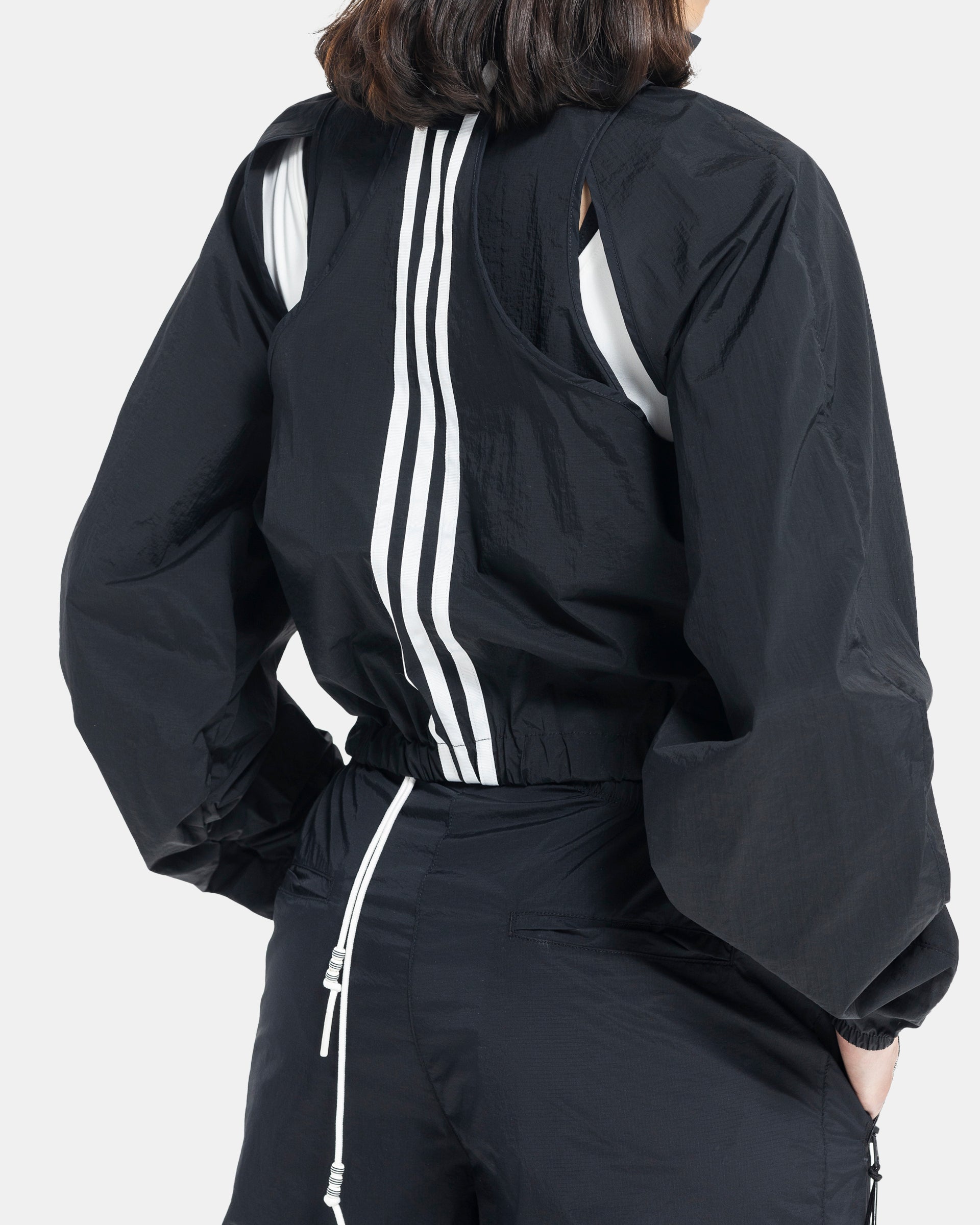 Female model wearing RUI x Adidas Black Jacket on white background