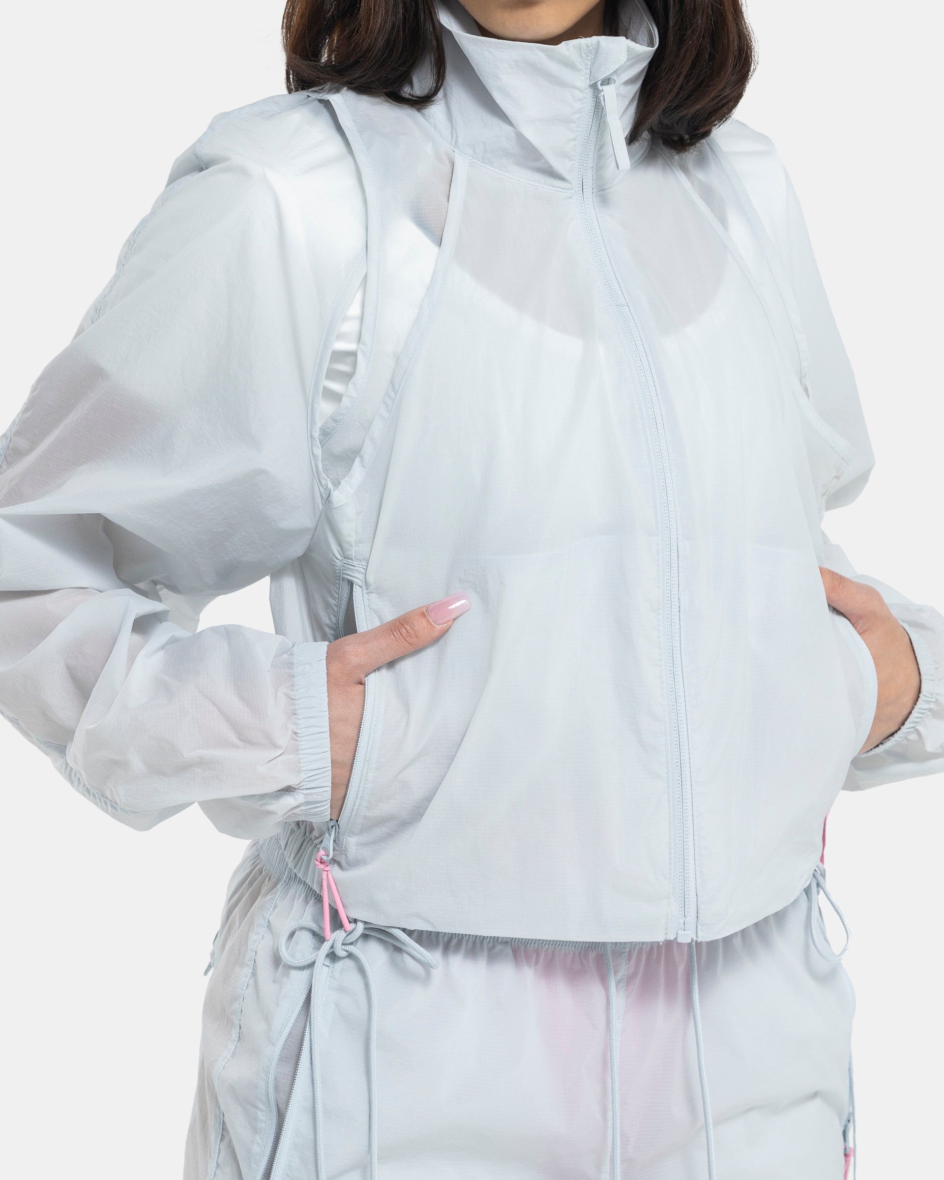 Female model wearing RUI x Adidas Pink Jacket on white background