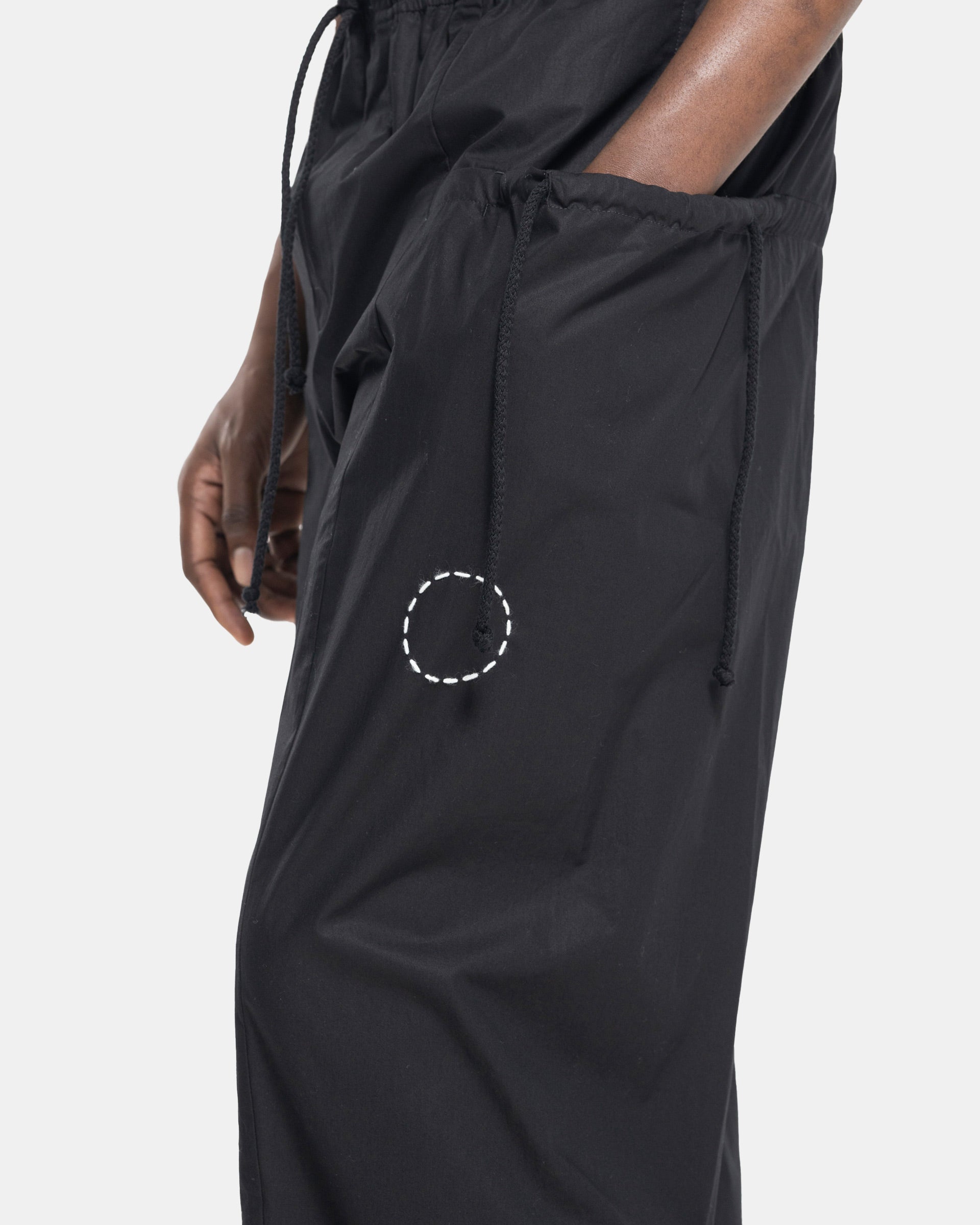 Close up model wearing Craig Green Circle Trouser in Black on white background