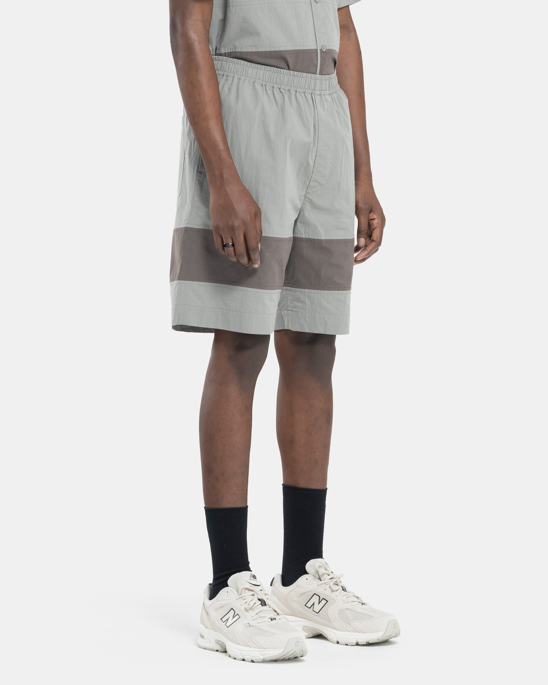 Model wearing Craig Green Barrel Shorts in Grey on white background
