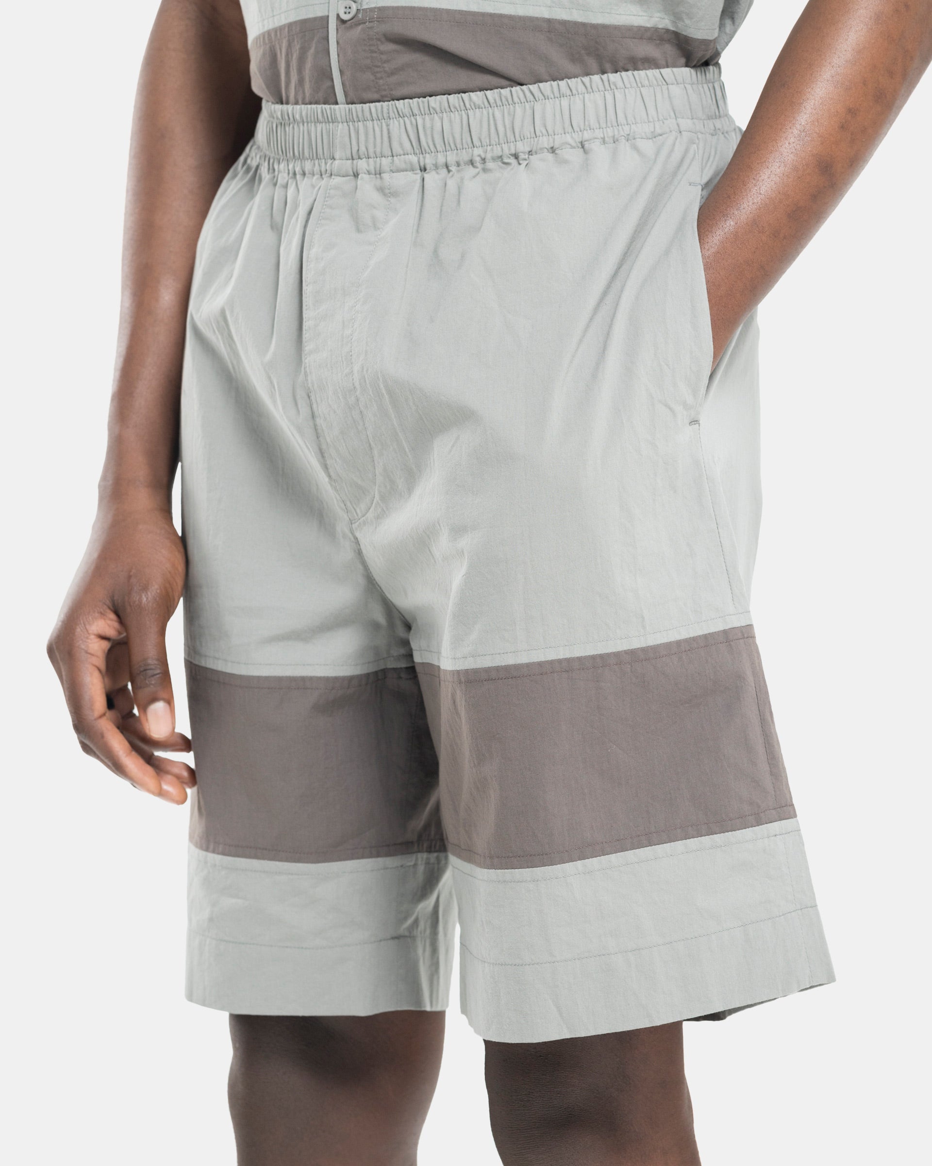Close up of Model wearing Craig Green Barrel Shorts in Grey on white background
