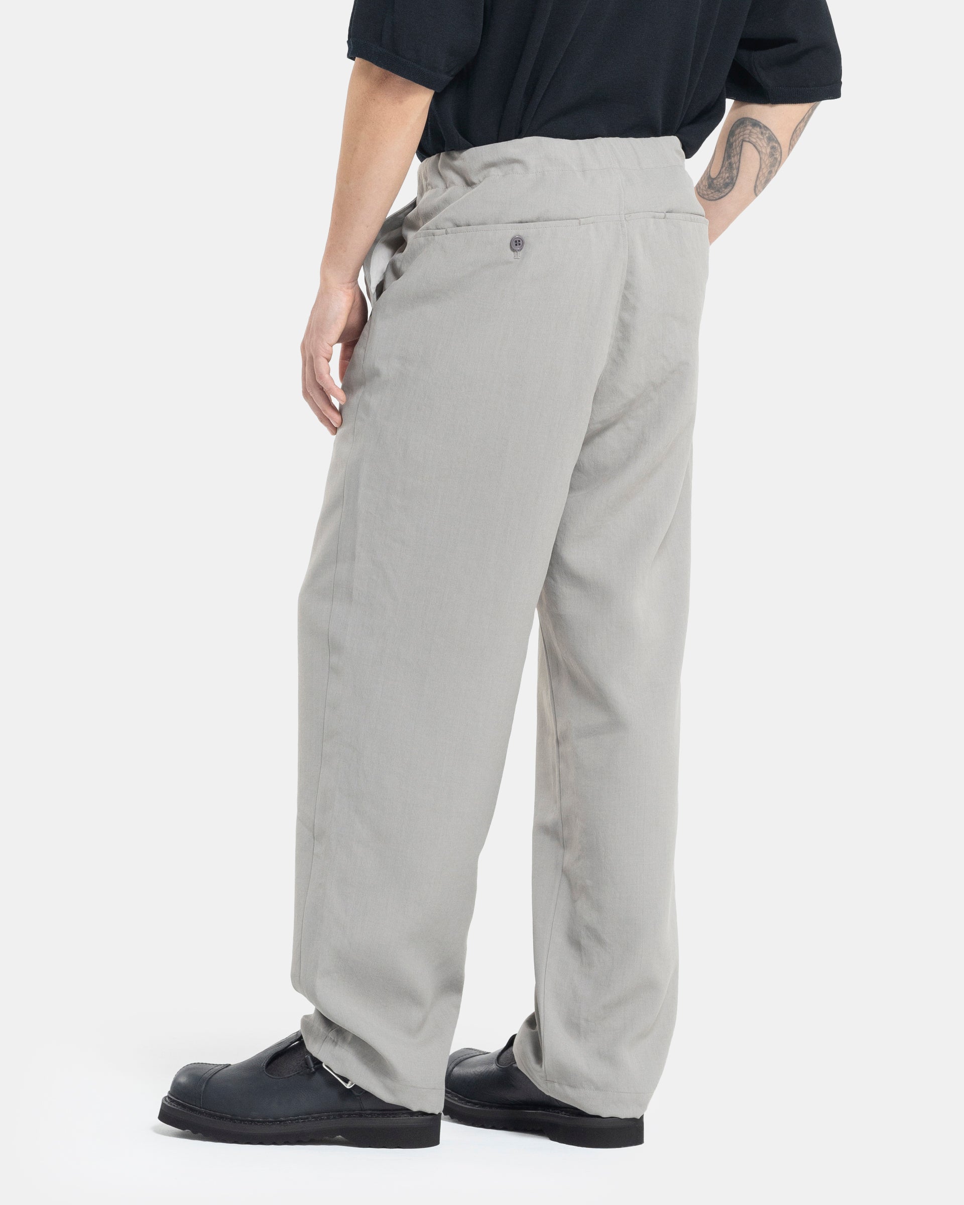 Male model wearing grey Still By Hand trousers on white background