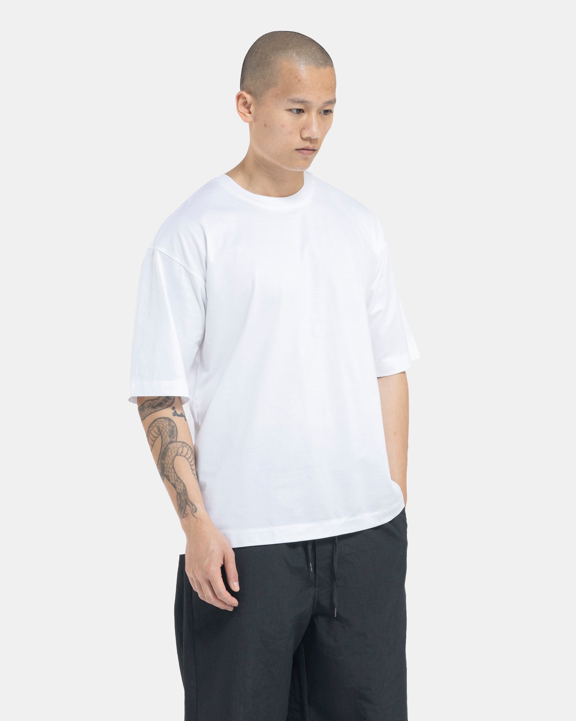 Male model wearing white Still By Hand T-shirt on white background