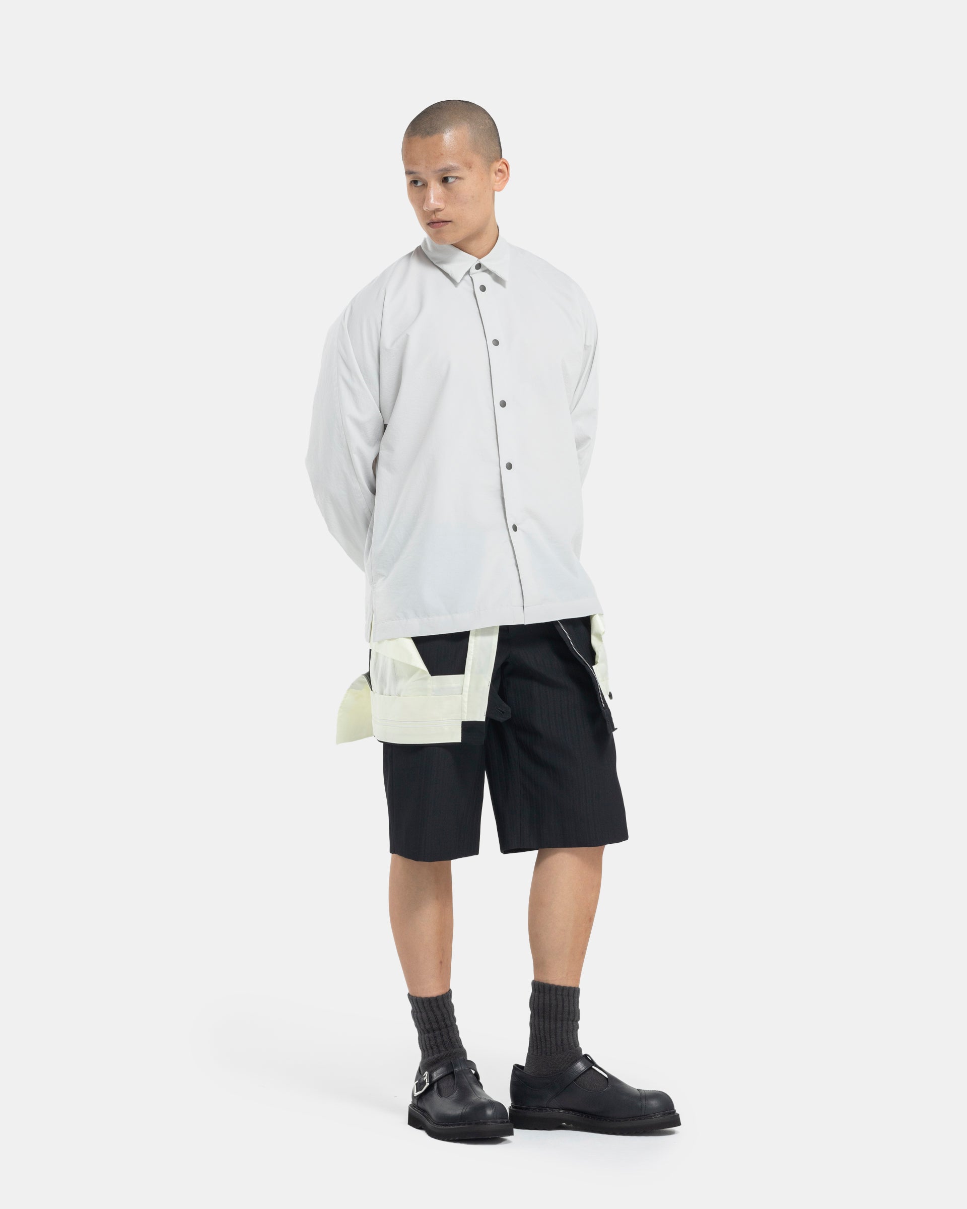 Male model wearing Comme Des Garçons Shorts on white background