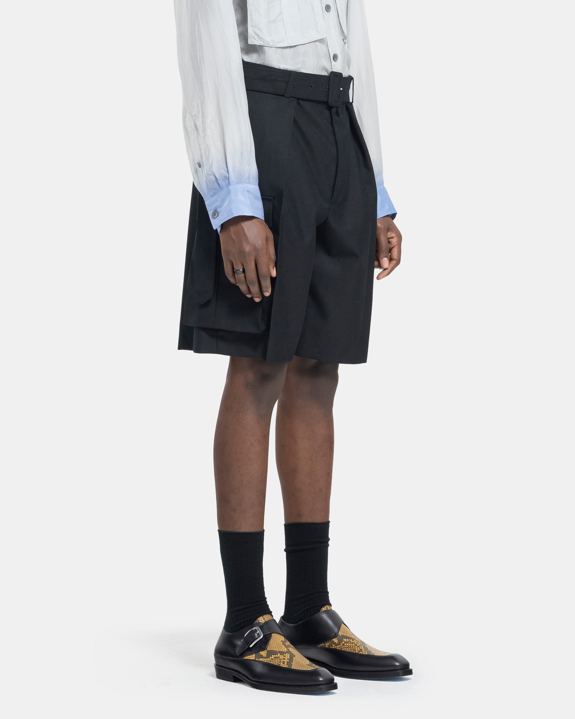 Model wearing Dries Van Noten Piers Bis Shorts in Black on white background