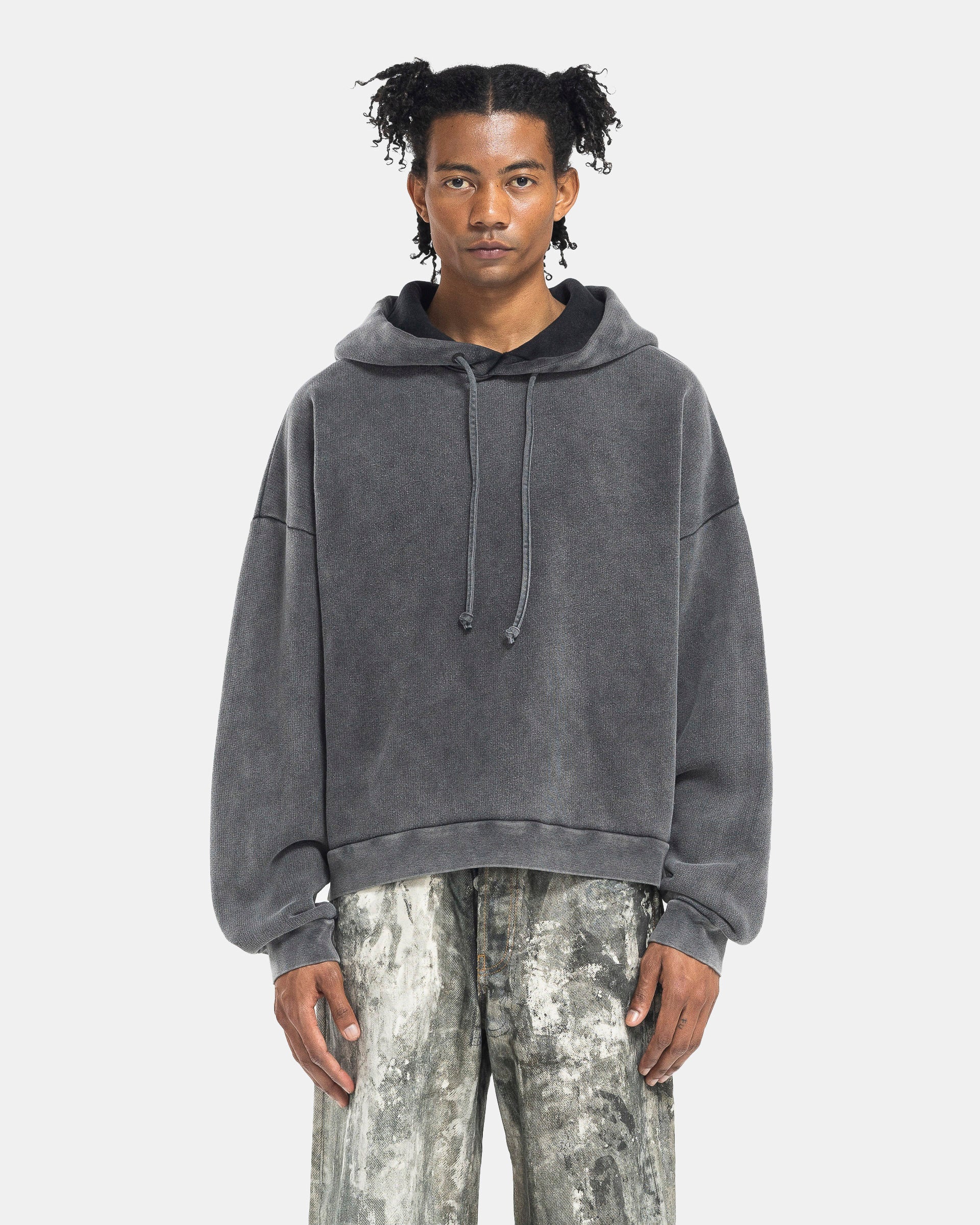 Model wearing Acne Studios Hooded Sweater in Faded Black on the white background