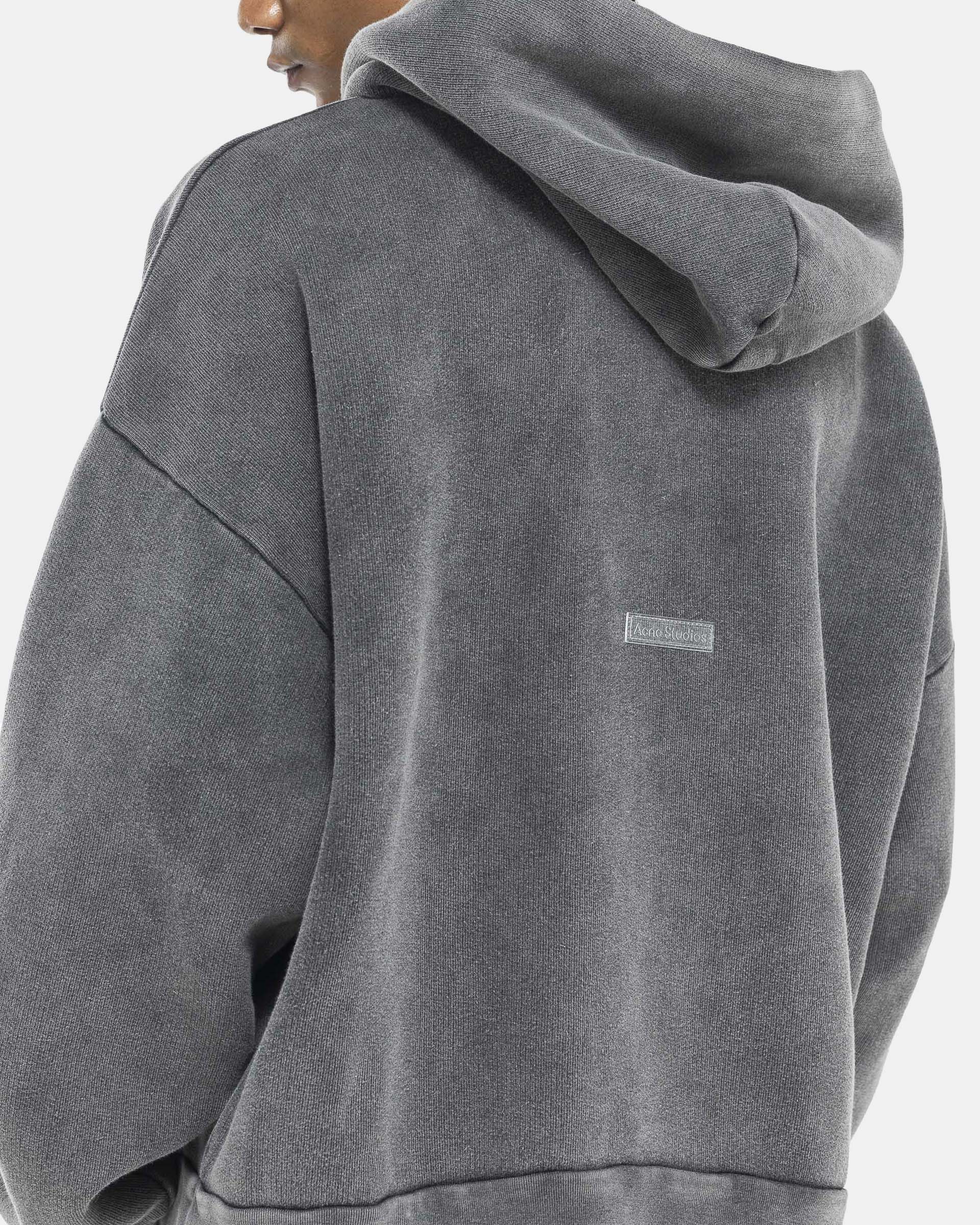 Model wearing Acne Studios Hooded Sweater in Faded Black on the white background
