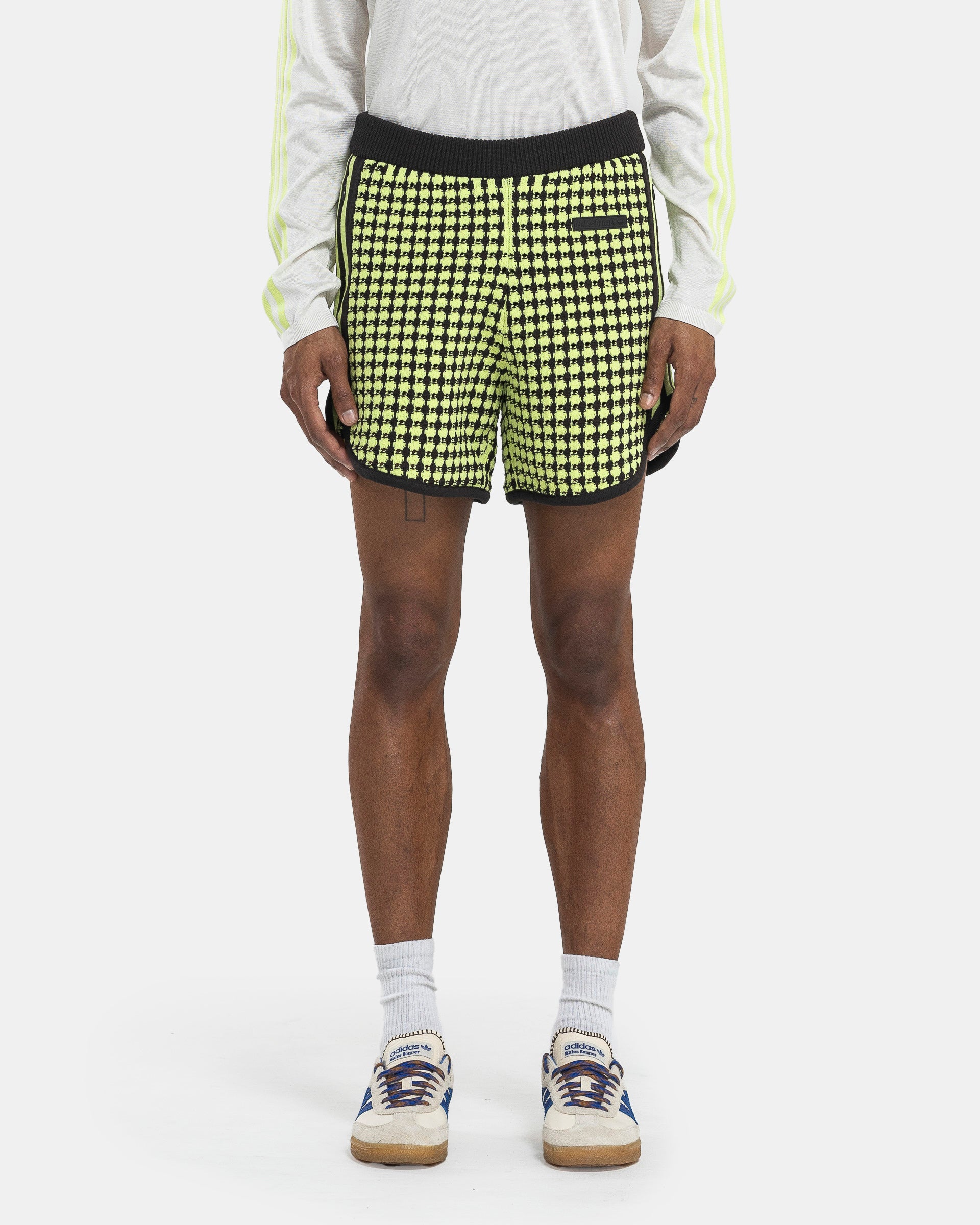 Model wearing Adidas Wales Bonner Crochet Shorts in Semi on the white background