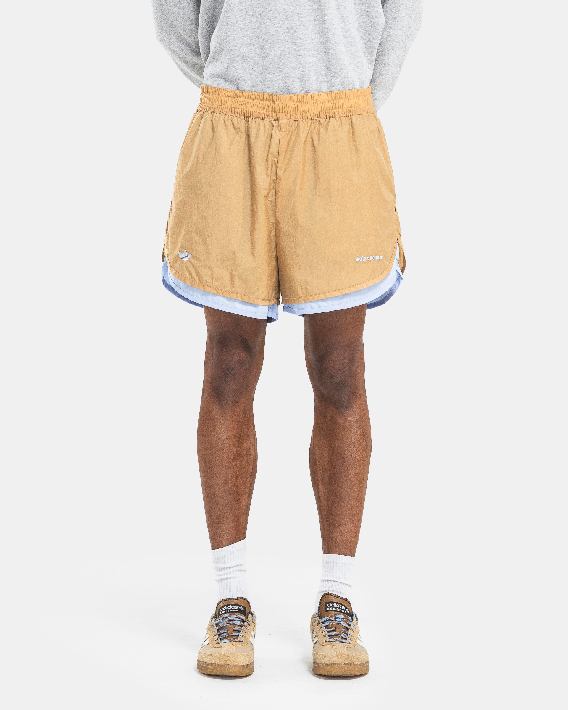 Model wearing Adidas Wales Bonner Layer Shorts in Beige on the white background