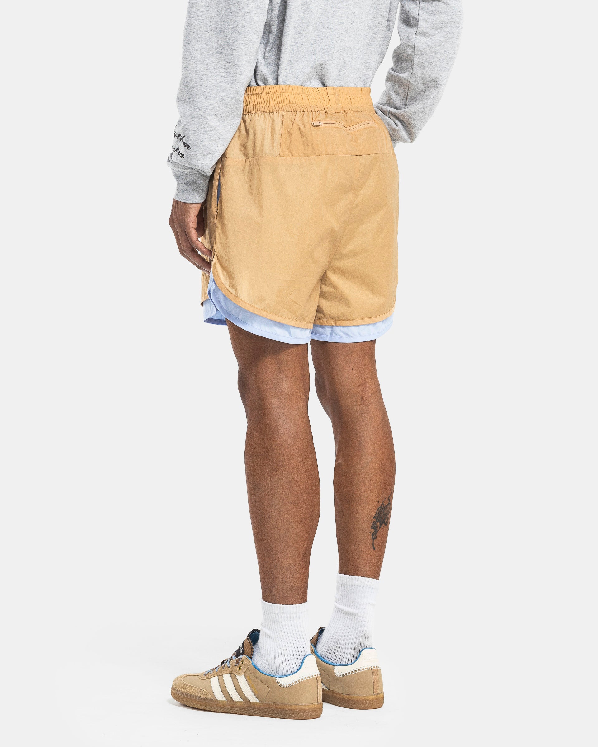 Model wearing Adidas Wales Bonner Layer Shorts in Beige on the white background