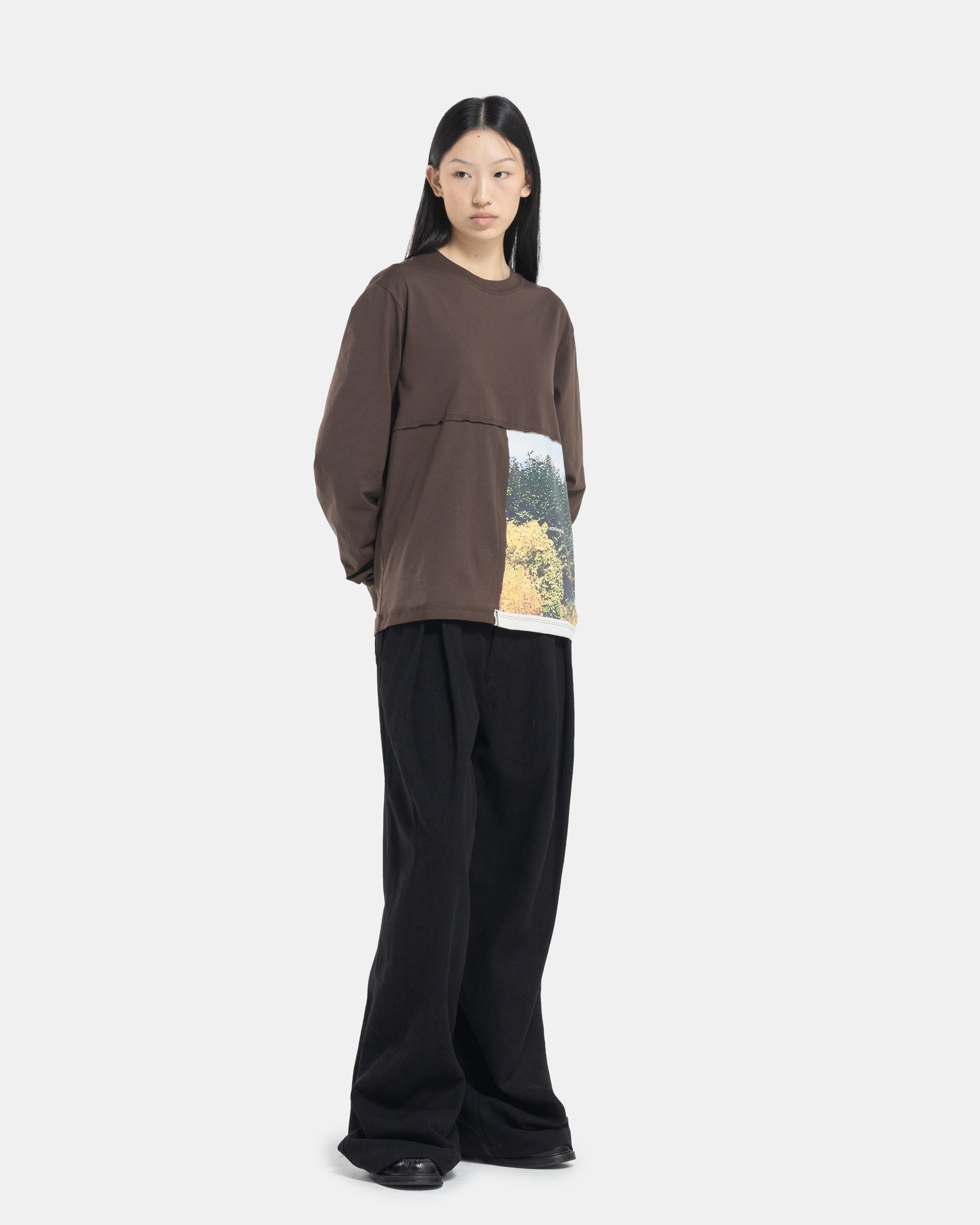 Female model wearing a brown Eckhaus Latta Lapped Longsleeve T-shirt with a printed design.